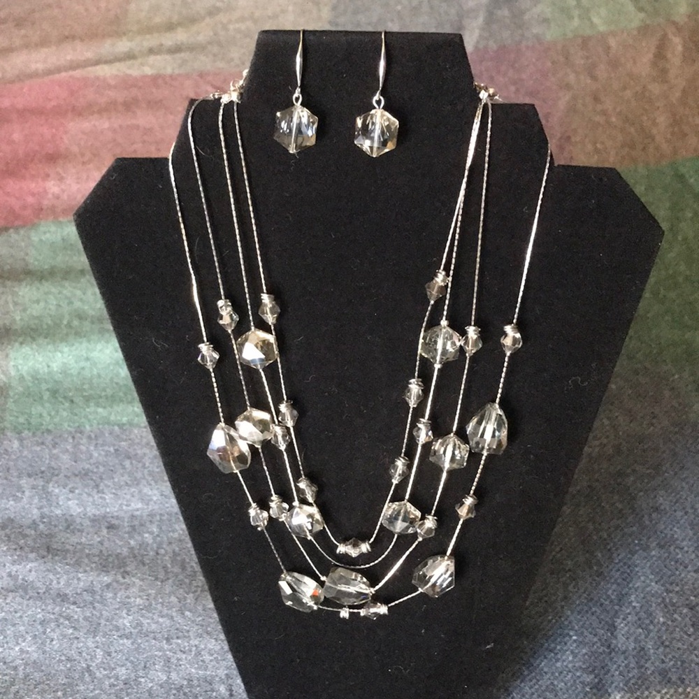 Four strand silver tone crystal beaded necklace and pierced earring set.
